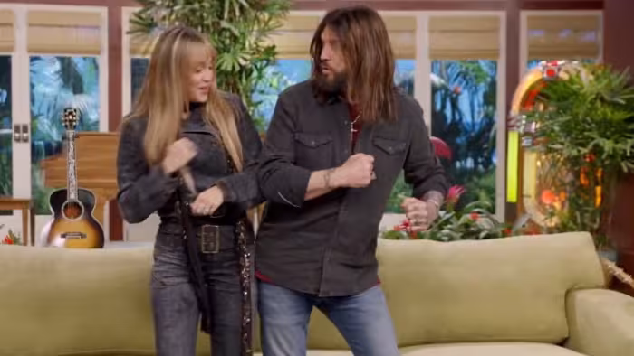 Hannah Montana 20th Anniversary Special screenshot 4:Miley Cyrus and her dad, Billy Ray Cyrus, do the Hannah Montana handshake together.