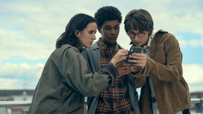 Harlan Coben's Shelter TV show screenshot 2: three high school friends huddle around a phone