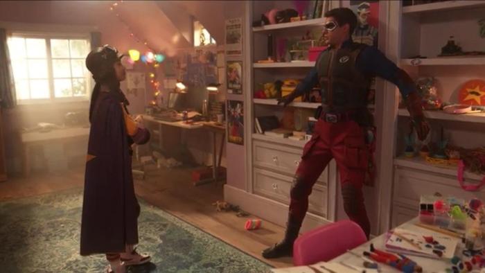 Henry Danger The Movie screenshot 2: Missy, in her SuperFan costume, looks at Henry, dressed as Kid Danger, who looks out of place in her bedroom.
