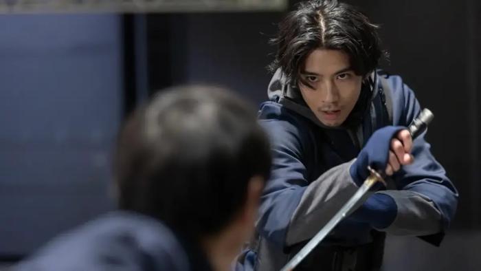 House of Ninjas TV show screenshot: A ninja holding a sword looks directly into the eyes of his opponent.