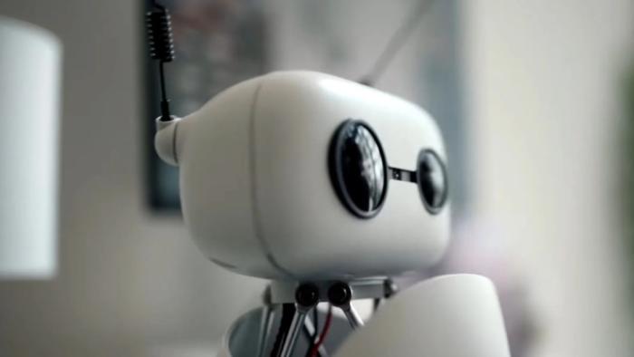 Instadocs: AI Gone Wild TV show screenshot 1: This image shows a small robot with a square head, big black eyes, and antennae