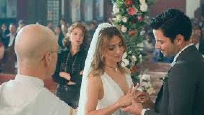 Just Alice TV show screenshot #1: A dark-haired man marries a brunette woman. He puts a ring on her finger.