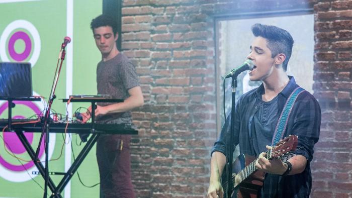 Kally's Mashup TV show screenshot 2: A young man is singing into a microphone while playing guitar.