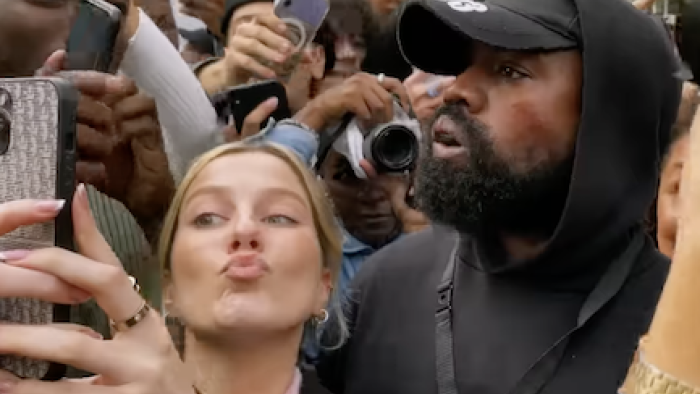 Kim vs. Kanye: The Divorce TV show screenshot 2: Kanye in crowd while young woman takes selfie with him.