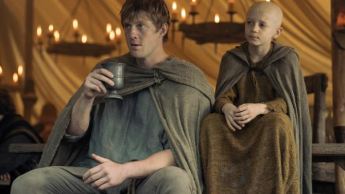 A Knight of the Seven Kingdoms TV show screenshot 1: Dunk and Egg sit together in an indoor shot, with candles behind them; both look serious 