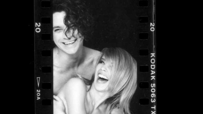 Kylie TV show screenshot 3: Black and white photo of Michael Hutchence hugging Kylie Minogue and smiling.