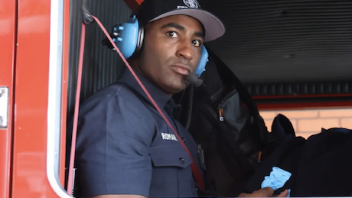 LA Fire & Rescue TV show screenshot 2:Engineer with headphones sitting in fire engine. 