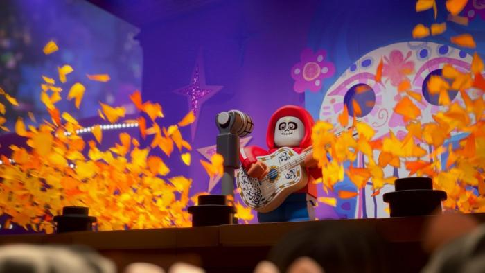 LEGO Pixar Bricktoons TV Show Poster Image: a LEGO Hector from Coco plays guitar with marigold petals flying around him