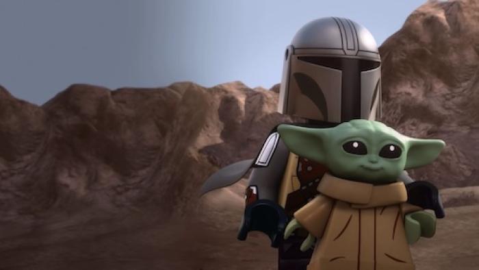 Lego Star Wars: The Mandalorian TV show screenshot: Mandalorian carries Grogu