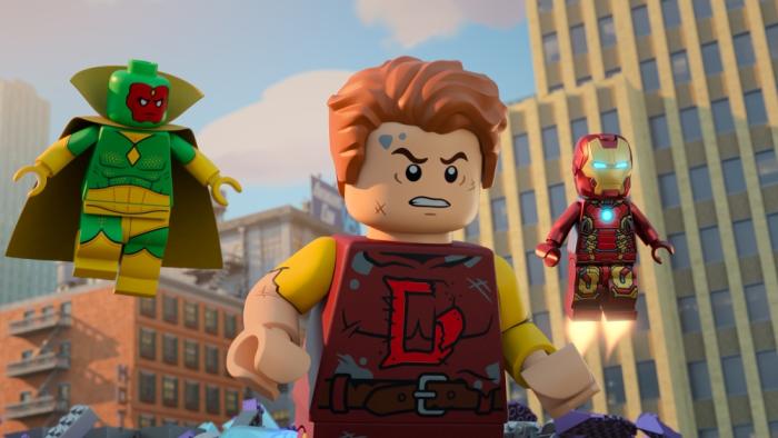 Lego Marvel Avengers Mission Demolition TV screenshot 3: Lego Dennis show signs of wear, looks angry at side. Iron Man and Vision float behind him