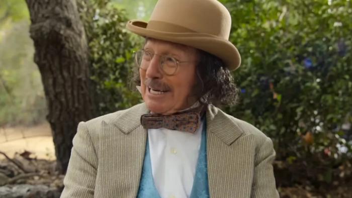 Life, Larry and the Pursuit of Unhappiness screenshot 3: Wearing period era clothing including a waistcoat, bowtie and bowler hat, David grimaces 