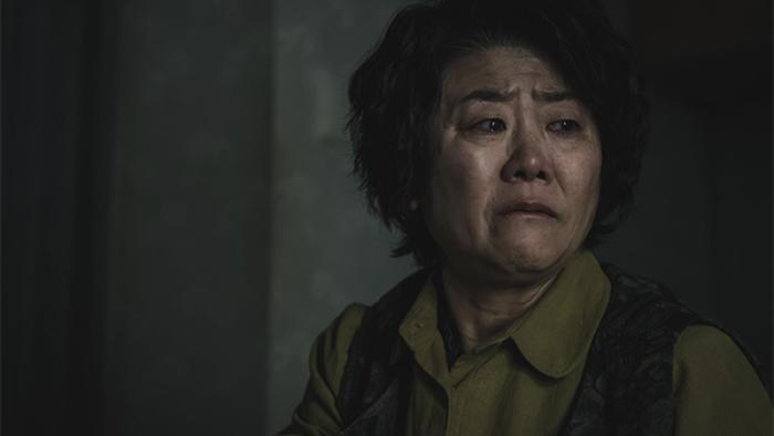 Light Shop TV show screenshot 3: A woman with short, dark hair is shown from the shoulders up, looking to the side with a pained and upset expression