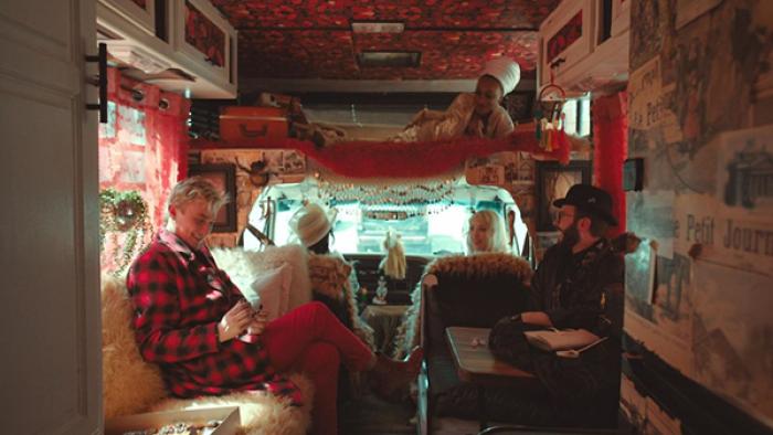 Living for the Dead TV show screenshot 1: The show's team is shown lounging and chatting inside their colorfully-decorated RV.