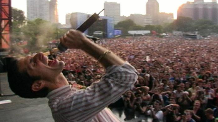 Lolla: The Story of Lollapalooza screenshot 1:Perry Farrell on stage in front of a large audience singing into a microphone