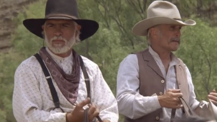 Lonesome Dove TV show screenshot 1: Gus and Call in cowboy hats riding horses.