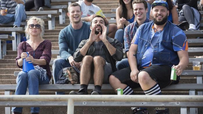 Looking TV Show: A group of friends, four men and one woman, sit in a crowd cheering from the bleachers
