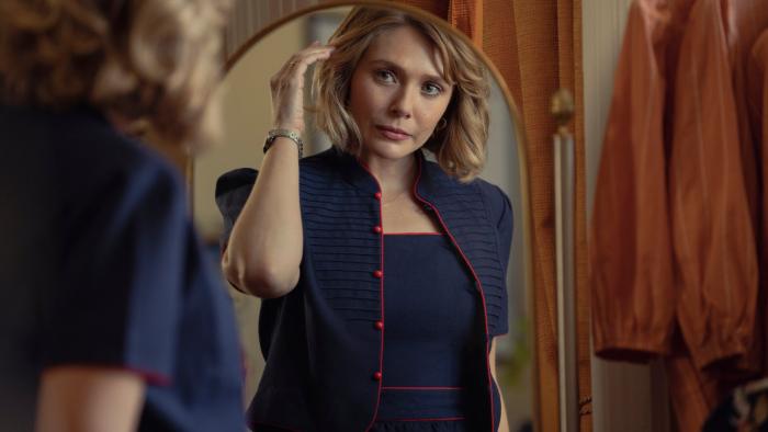 Love & Death TV show: a woman checks her hair in a full-length mirror