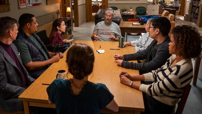 Lucky Hank TV show: Hank sits at the head of a table surrounded by his fellow English professors