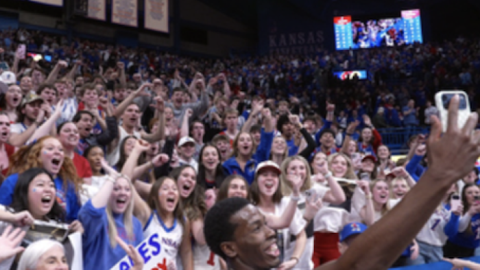 Made for March TV show screenshot 3: A Jayhawks player takes a selfie with people celebrating in the bleachers.