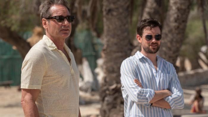 Malice TV show screenshot 3: Jamie and Adam stand together on a beach, looking at something off-camera