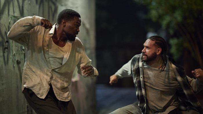 Man on Fire TV show screenshot 1: Yahya Abdul-Mateen II aims a punch at a man. Mateen II wears a white tank top, white button shirt, and brown pants.