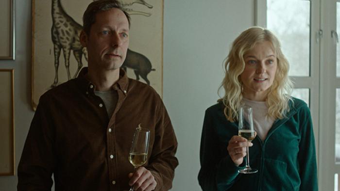 MILF of Norway TV show screenshot 2: Lars and Lene pictured from the waist up, holding glasses of champagne.