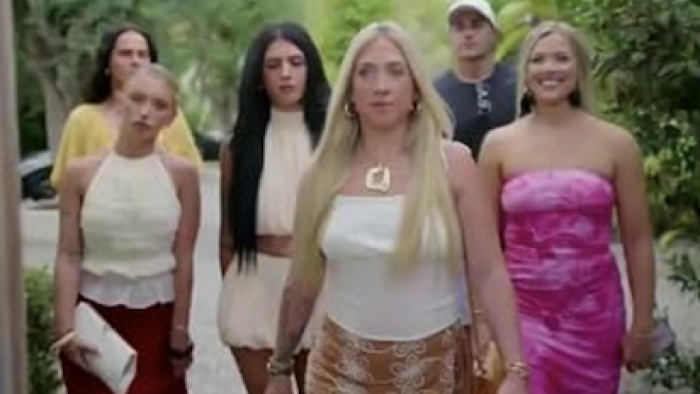 Million Dollar Nannies TV show screenshot-2: Group of six people walking outdoors, smiling and dressed in summer attire.