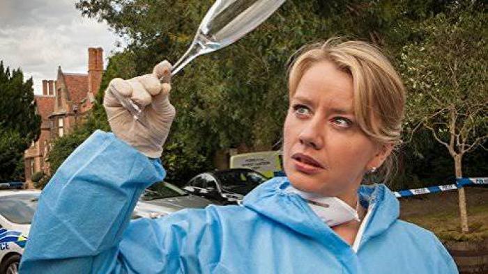 Midsomer Mysteries: Forensic investigator examining a glass outdoors.
