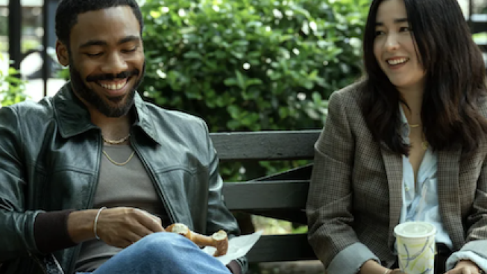 Mr. & Mrs. Smith TV show screenshot 1: Danny Glover and Maya Erskine as John and Jane Smith talking on bench.
