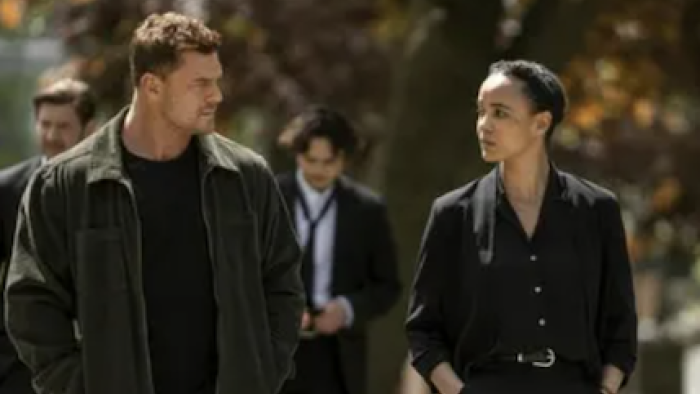Neagley TV show screenshot 1: Jack Reacher and Neagley walk and talk together dressed in black.