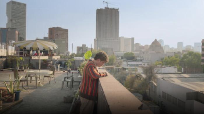Nothing to See Here TV show screenshot 2: Alexis Arroyo is on a rooftop from where other buildings can be seen.