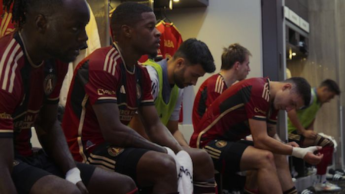 Onside: Major League Soccer TV show screenshot 2: Players in red and white shirts sit in locker room.
