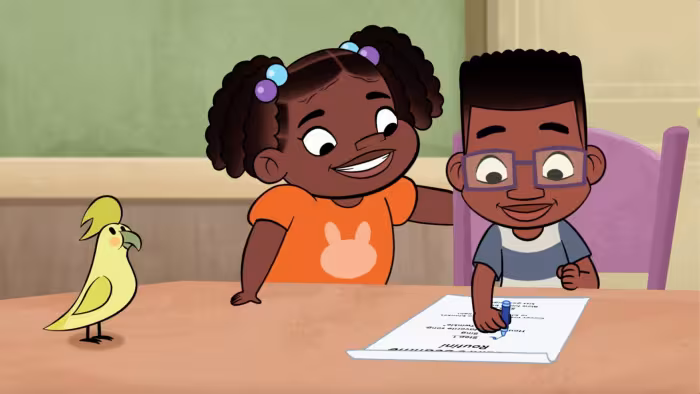 Phoebe & Jay TV: Phoebe helps Jay who's writing a poster for a missing pet. A yellow bird stands next to them of the desk.
