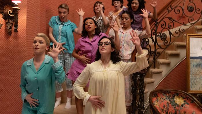 Grease: Rise of the Pink Ladies TV show: 8 teenage girls dance on a curved staircase while wearing pajamas.