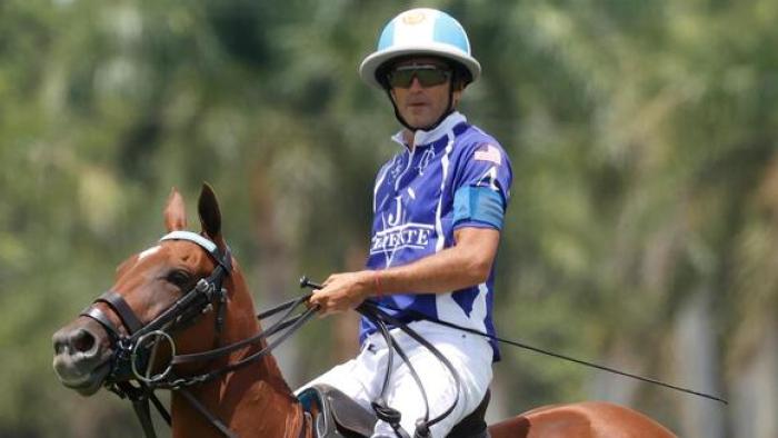 Polo TV show screenshot: A man in blue sits on a brown horse