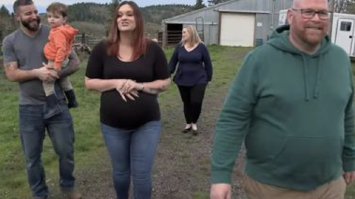 Polyfamily TV show screenshot 3: Tyler holds toddler as adults walk on farm.