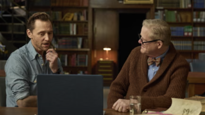 Pompeii: Out of Time with Tom Hiddleston screenshot 2: Hiddleston talking with gray haired man at a table with a laptop in a library setting.