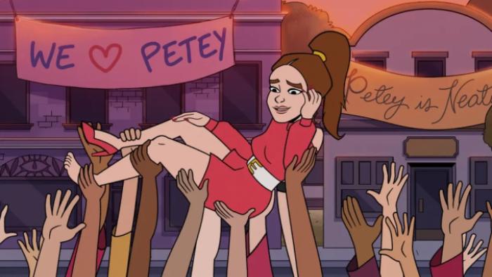 Praise Petey: Petey is held up by the hands of her followers as she crowd surfs. A banner reads "We love Petey" above her body. 