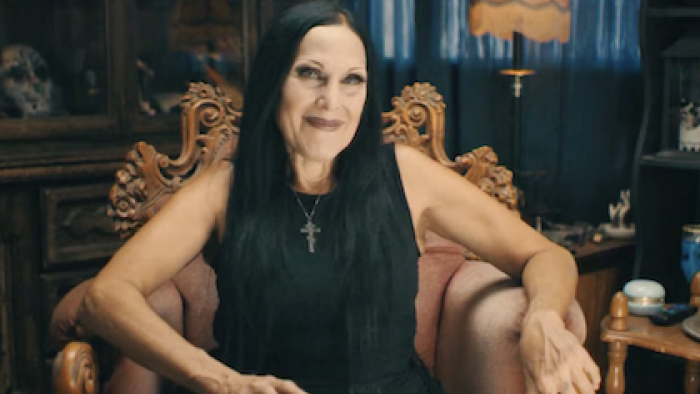 Richard Ramirez: The Night Stalker Tapes screenshot-2:  Eva O sits in black dress and long black hair.