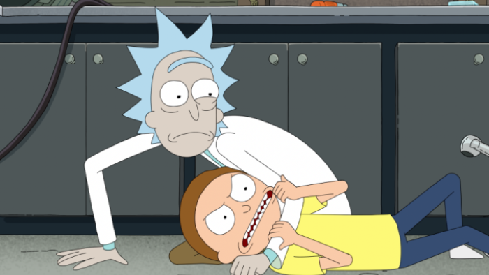 Rick and Morty: Season 7: Rick uses his elbow to hold Morty down on a lab floor, both looking surprised