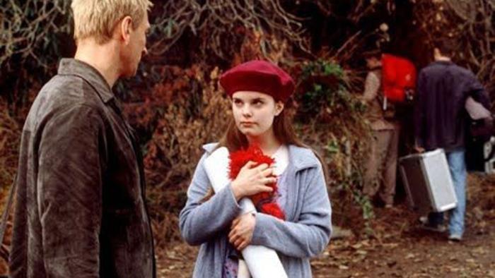 Stephen King's Rose Red TV show screenshot: a man talks to a small girl holding a doll.