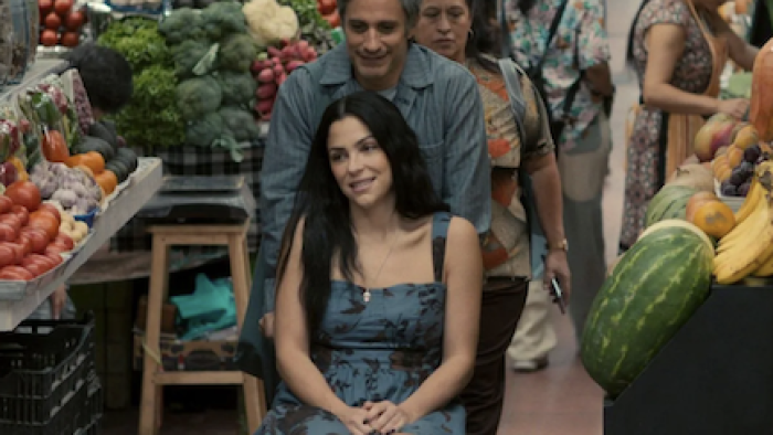 Santita TV show screenshot 2: Alejandro pushes Santita in her wheelchair through a food market.