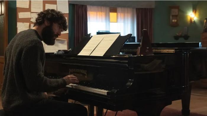 The Last Night at Tremore Beach screenshot: A White man plays piano as lamps gently lit up the room in the background