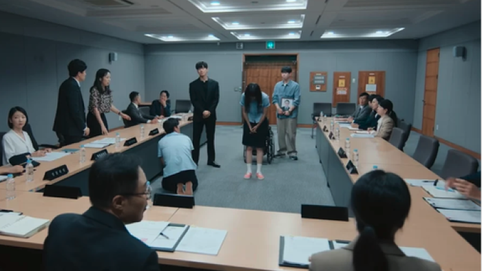 Teach You A Lesson TV show screenshot 2: A meeting room with seated people and two standing in the center, one of them bowing their head.