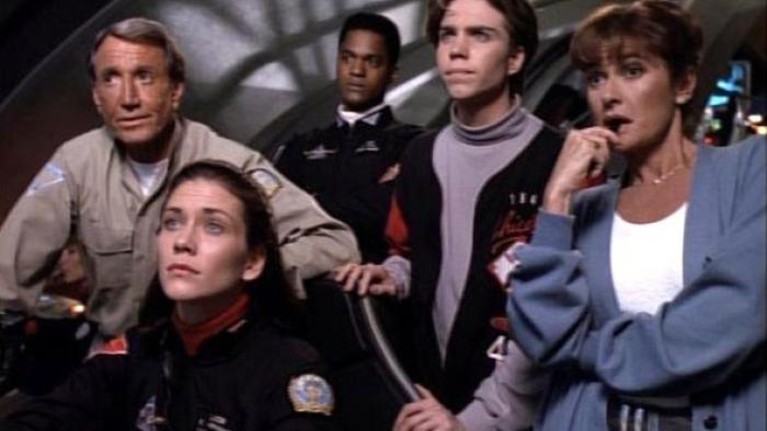 Seaquest DSV TV show screenshot: A group of submarine workers stand next to each other looking at the instrument board of the submarine with dismay.