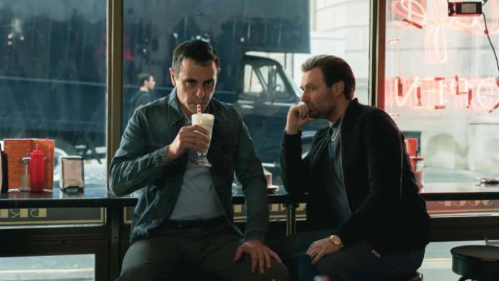 Sexy Beast TV show screenshot 2: Don and Gal sit together on stools at a diner; Gal is drinking a milkshake.