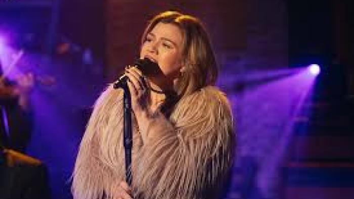 Songs and Stories with Kelly Clarkson TV show screenshot #1: Clarkson sings while wearing a tan, furry jacket
