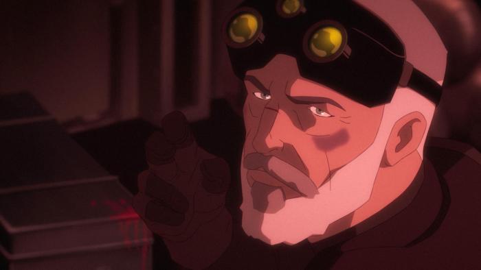 Sam, with goggles raised on forehead, pointing fingers.