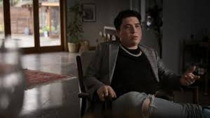 Spy High TV show screenshot #1: A young man/teen is seated indoors, talking to the camera.