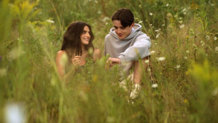Sterling Point TV show screenshot 2: Annie and Ellis sit close together in a field filled with tall yellow flowers